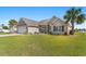 Well-maintained home featuring lush green lawn and mature palm trees on a sunny day at 509 Fallen Leaf Ct., Myrtle Beach, SC 29588