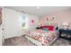 Bright bedroom with a colorful floral bedspread, pink accent wall, and natural light from the window at 5153 Yellowstone Dr., Conway, SC 29526