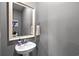 This half-bathroom features a pedestal sink, framed mirror, and neutral wall paint at 5371 Knobcone Loop # D, Myrtle Beach, SC 29577