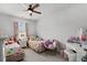 Bright bedroom with two twin beds, pastel decor, a ceiling fan, and a window offering ample natural light at 5371 Knobcone Loop # D, Myrtle Beach, SC 29577