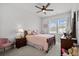 Cozy bedroom featuring a wooden bed, a nightstand, a small pink chair and a big window offering ample natural light at 5371 Knobcone Loop # D, Myrtle Beach, SC 29577