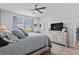 Serene main bedroom with a king-size bed, light gray walls, a ceiling fan, and a view to the backyard at 5371 Knobcone Loop # D, Myrtle Beach, SC 29577