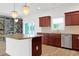 Kitchen with dark wood cabinets, granite countertops, an island, and stainless steel appliances at 561 Irees Way, Longs, SC 29568