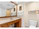 Bathroom features a spacious wooden vanity, a large mirror, towels, and a toilet at 603 S Ocean Blvd. # 1205, North Myrtle Beach, SC 29582