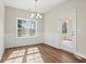 Dining room with modern wainscoting, hardwood floors, and a view of the outdoors through a large window at 605 Carter Reid Ct., Longs, SC 29568