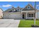 Charming home featuring a three-car garage, well-manicured lawn, and inviting entrance at 609 Carter Reid Ct., Longs, SC 29568