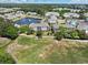 Scenic aerial view of condo buildings near a pond, golf course, and swimming pool in a lush, green community at 6203 Catalina Dr. # 1832, North Myrtle Beach, SC 29582