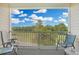 Outdoor balcony seating overlooks a green common area and blue sky at 6203 Catalina Dr. # 1832, North Myrtle Beach, SC 29582