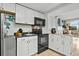 Compact white kitchen featuring stainless steel appliances and overhead microwave and air fryer at 6900 N Ocean Blvd. # 208, Myrtle Beach, SC 29572