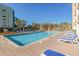 Large outdoor pool with lounge chairs and tropical palm trees surrounding it at 6900 N Ocean Blvd. # 208, Myrtle Beach, SC 29572