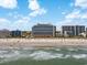Hotel towers on a beach with many people surfing, swimming, and relaxing under the sun with fluffy clouds at 7100 Ocean Blvd. N # 1425, Myrtle Beach, SC 29572