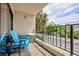 Balcony seating area overlooking a street, buildings, and palm trees at 7509 N Ocean Blvd. # 101, Myrtle Beach, SC 29572