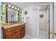Bathroom vanity with granite countertop, decorative mirror, and bright wallpaper at 7509 N Ocean Blvd. # 101, Myrtle Beach, SC 29572