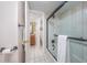 Bathroom featuring a shower tub, white tiling, and adjacent bathroom at 7509 N Ocean Blvd. # 101, Myrtle Beach, SC 29572