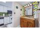 Bright bathroom featuring lemon-themed wallpaper, granite countertop, and white tiled floors next to the kitchen at 7509 N Ocean Blvd. # 101, Myrtle Beach, SC 29572