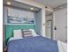 Comfortable bedroom featuring a stylish bed, ocean-themed decor, and adjacent view of the kitchen area at 7509 N Ocean Blvd. # 101, Myrtle Beach, SC 29572