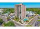 An exterior view of a high-rise building with a swimming pool and parking, close to the beach at 7509 N Ocean Blvd. # 101, Myrtle Beach, SC 29572