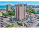 Elevated exterior view of high rise building with a pool and parking lot set against ocean and city views at 7509 N Ocean Blvd. # 101, Myrtle Beach, SC 29572