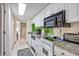 Bright kitchen featuring white cabinets, granite countertops, and stainless steel appliances with a view to hallway at 7509 N Ocean Blvd. # 101, Myrtle Beach, SC 29572