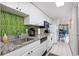 Well-lit kitchen featuring white cabinetry, granite countertops, and stainless steel appliances with a view to living room at 7509 N Ocean Blvd. # 101, Myrtle Beach, SC 29572