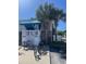 Exterior of building with bike rack, reserved parking sign, and lush palm trees at 804 12Th Ave. S # 218, North Myrtle Beach, SC 29582