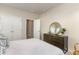 Cozy bedroom featuring a dresser with round mirror and a comfortable bed with patterned pillows at 867 Ireland Dr., Longs, SC 29568