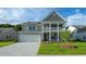 Charming two-story home with a gray exterior, landscaped lawn, and attached two-car garage at 867 Ireland Dr., Longs, SC 29568