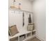 Functional mudroom featuring built-in bench with storage, coat hooks, and decorative pillows at 867 Ireland Dr., Longs, SC 29568