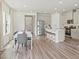 Bright, open-concept with island kitchen, stainless appliances, and dining area with stylish chairs at 871 Cypress Preserve Circle, Longs, SC 29568