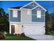 Charming two-story home boasts blue and gray siding, a two-car garage, and a welcoming front door and landscaped yard at 882 Cypress Preserve Circle, Longs, SC 29568