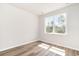 A bright bedroom features wood-look flooring and a large window with views at 885 Ireland Dr., Longs, SC 29568