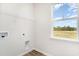 Bright laundry room features a window with natural light, storage shelf and utility connections at 885 Ireland Dr., Longs, SC 29568