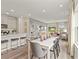 Open-concept dining area with gray chairs, white table, hardwood floors, and view to the living area and kitchen at 886 Cypress Preserve Circle, Longs, SC 29568