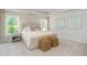 This stunning main bedroom features large windows, neutral decor, and two woven hassocks at 890 Ireland Dr., Longs, SC 29568