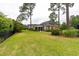 A spacious backyard features a screened porch, lush lawn, and mature trees, creating a serene outdoor space at 912 Berwick Ln., Myrtle Beach, SC 29579
