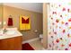 Well-lit bathroom featuring a flower-themed shower curtain and a vanity sink with a warm wall color scheme at 912 Berwick Ln., Myrtle Beach, SC 29579