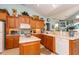 Well-lit kitchen with wooden cabinets, modern appliances, and an island counter, perfect for cooking at 912 Berwick Ln., Myrtle Beach, SC 29579