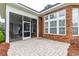 Exterior view showcasing a brick patio, a screened patio, and beautiful landscaping at 912 Berwick Ln., Myrtle Beach, SC 29579