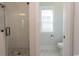 Bright bathroom with a glass shower, toilet, and a window providing natural light at Simpson Creek Dr., Loris, SC 29569