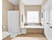 Large soaking tub with tile surround and plenty of natural light at 1005 Kelly Ct., Garden City Beach, SC 29576
