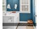 Main level powder room featuring blue walls, white cabinets and complementary towels at 1005 Kelly Ct., Garden City Beach, SC 29576