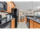 View of the kitchen and living area showing black appliances and wood cabinets at 1005 Kelly Ct., Garden City Beach, SC 29576