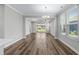 Spacious dining room with wood-look floors, large windows, a modern chandelier, and an open layout for versatile living at 1031 Cascade Loop, Little River, SC 29566