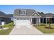 Charming single-Gathering home with a gray exterior, well-manicured lawn, and a two-car garage at 1031 Cascade Loop, Little River, SC 29566