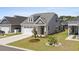 Inviting single-story home featuring a two-car garage, landscaped yard, and charming front porch at 1031 Cascade Loop, Little River, SC 29566