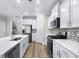 Stylish kitchen featuring white cabinets, stainless steel appliances, a mosaic backsplash, and a functional island with a sink at 1031 Cascade Loop, Little River, SC 29566