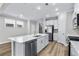 Bright kitchen with white cabinets, stainless steel appliances, a center island with seating, and ample natural light at 1031 Cascade Loop, Little River, SC 29566