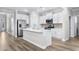 Bright kitchen boasts white cabinetry, a large island with a sink, and stainless steel appliances for a contemporary look at 1031 Cascade Loop, Little River, SC 29566