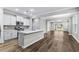 Modern open-concept kitchen with white cabinets, a large island, and stainless steel appliances, flowing into the living area at 1031 Cascade Loop, Little River, SC 29566