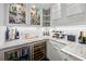 Elegant bar area with granite countertops, wine cooler, beverage fridge, and stylish glass cabinets for storage and display at 109 Pioneer Loop, Georgetown, SC 29440